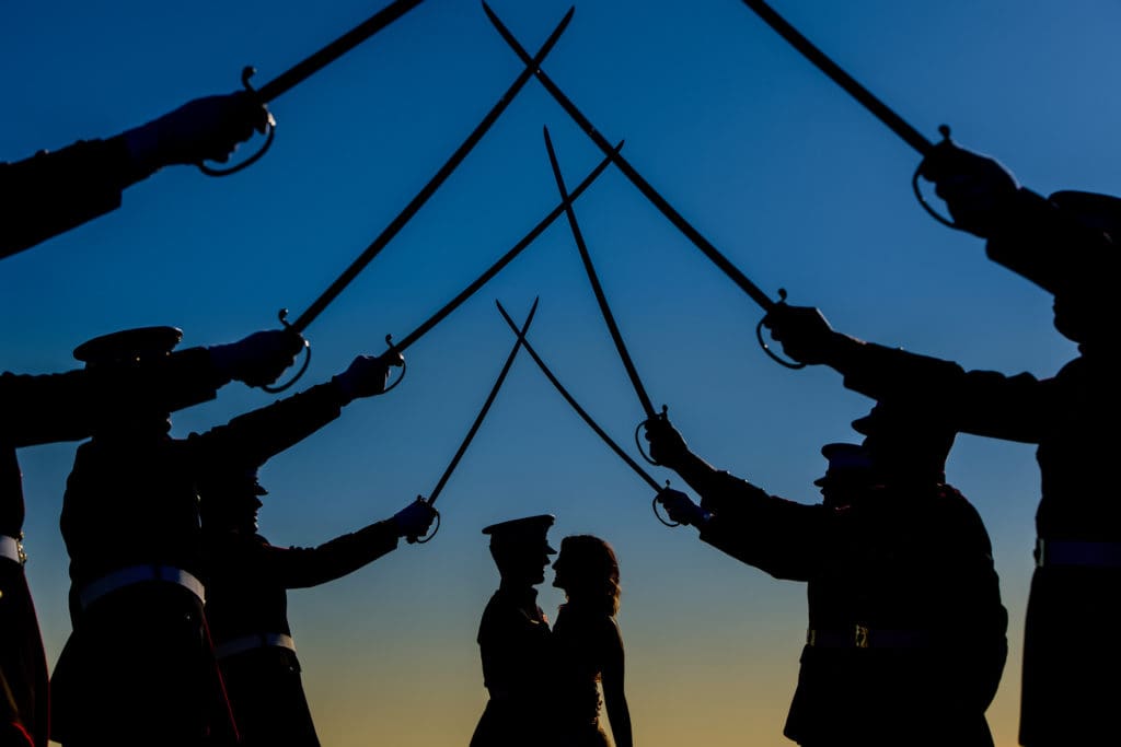 military bride and groom salute in silhouette