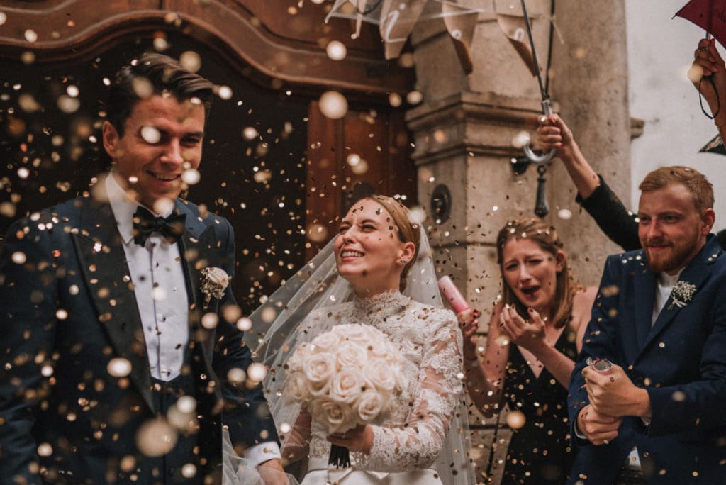 happy wedding couple with confetti guests exit outside vienna austria photography