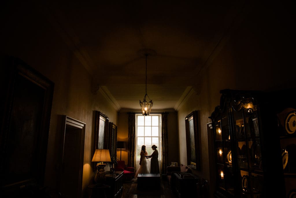 natural light warm glow wedding photography bride and sister getting ready