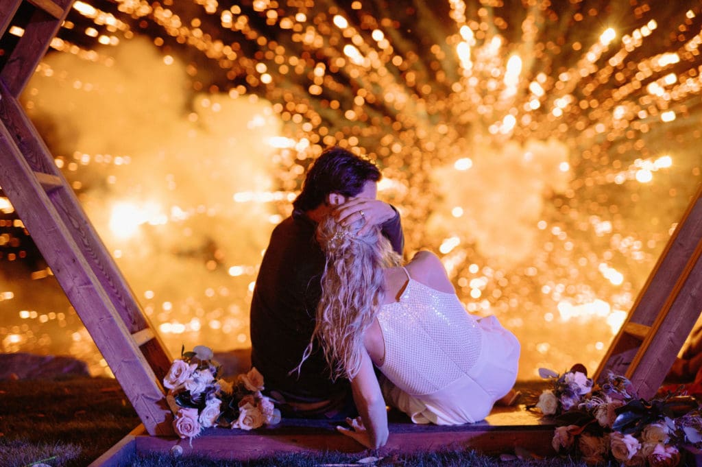 Fireworks with couple watching culminate in the creative wedding coverage of day.