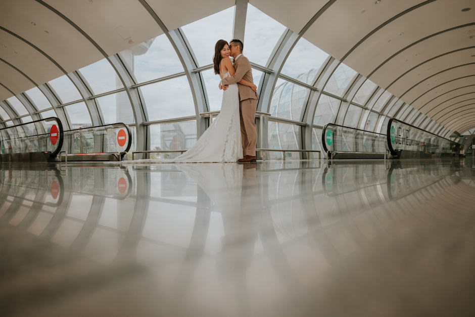 Beautiful architectural lines at the Singapore airport frame this couple's wedding photo.