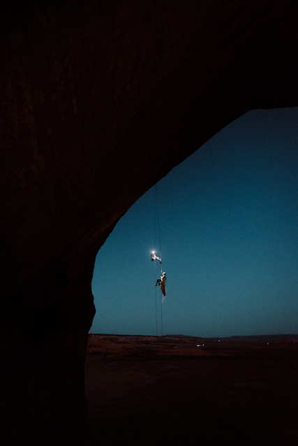 bride and groom rapelling off cliff in adventurous wedding and elopement photo.