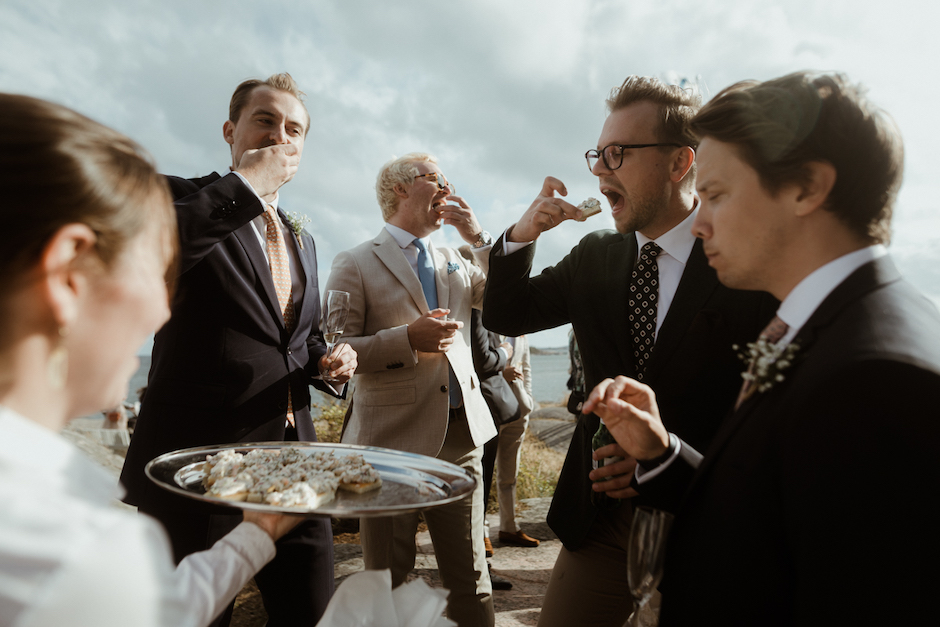 candid wedding photo of people eating at wedding with mouths open.
