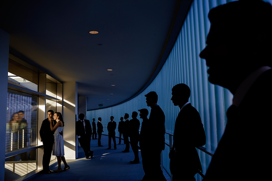 bride and groom with groomsmen in silhouette in back of them.