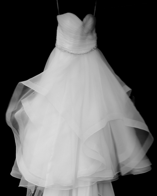 movement shown in wedding dress hanging from hanger.