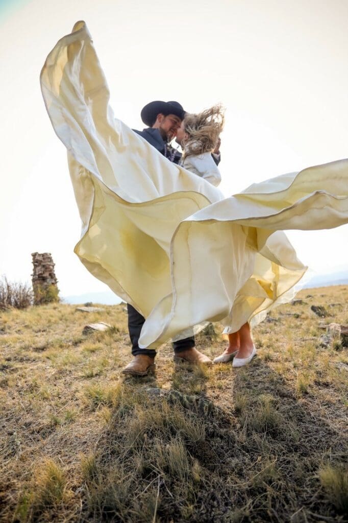 bride and groom embracing as dress swirls around them.