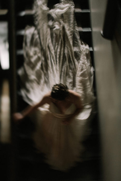 Bride running down the steps with movement and unique photo lighting.