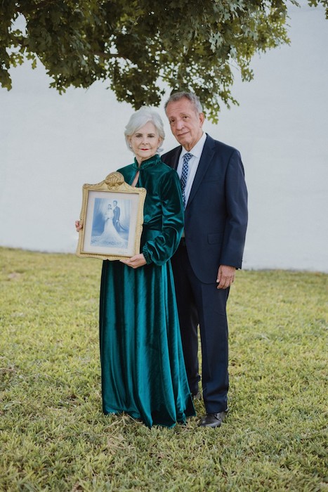 older couple holding framed photo memory portrait