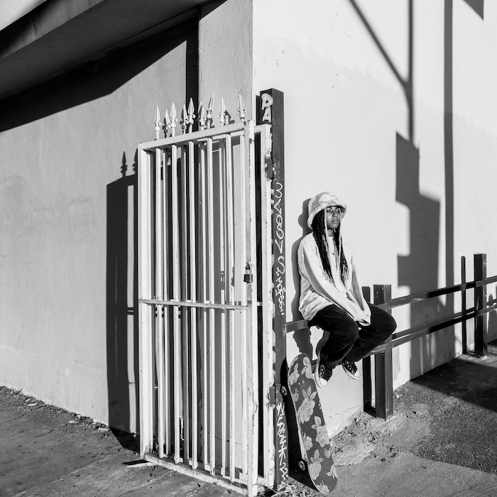 photo of Samatrah Burroughs on fence with skaeboard.