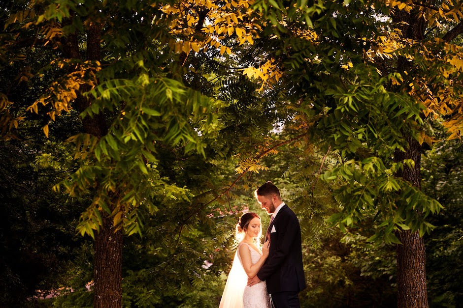 bride and groom with leafy trees surrounding them.