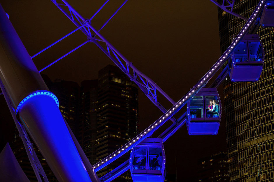 Ferris wheel at night with couple inside one of the gondolas.