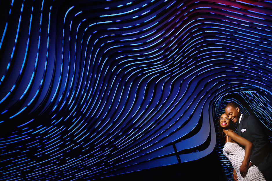 Black couple shown agains cool blue ceiling of waves.