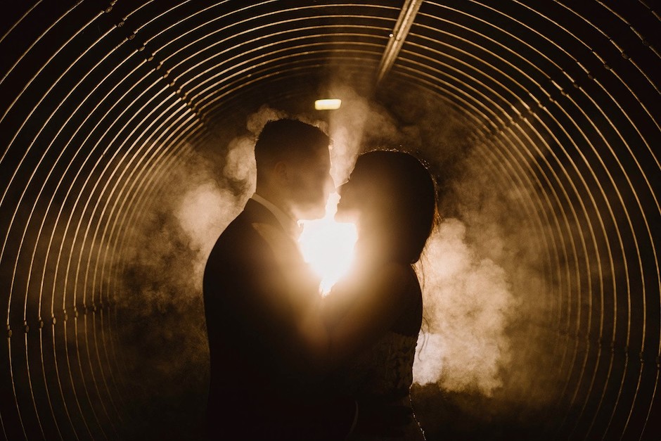 Couple in tunnel with fog behind them.