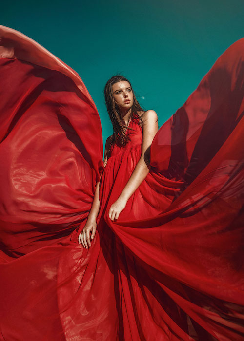 image of woman in red dress against colored backdrop.